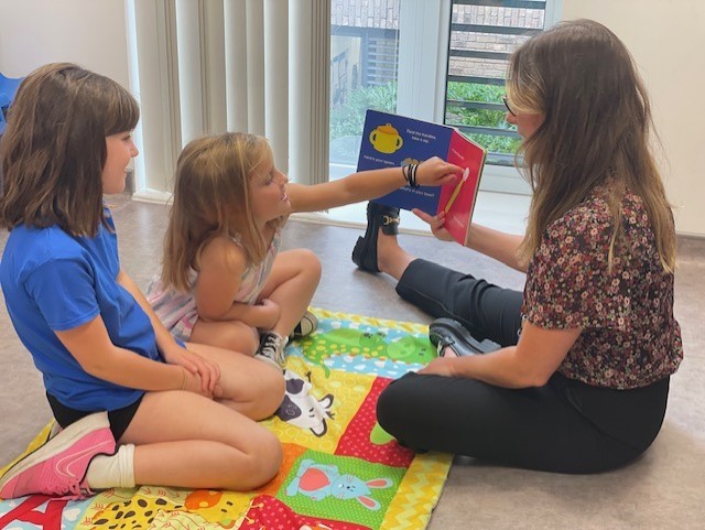 a woman reading to 2 young girls