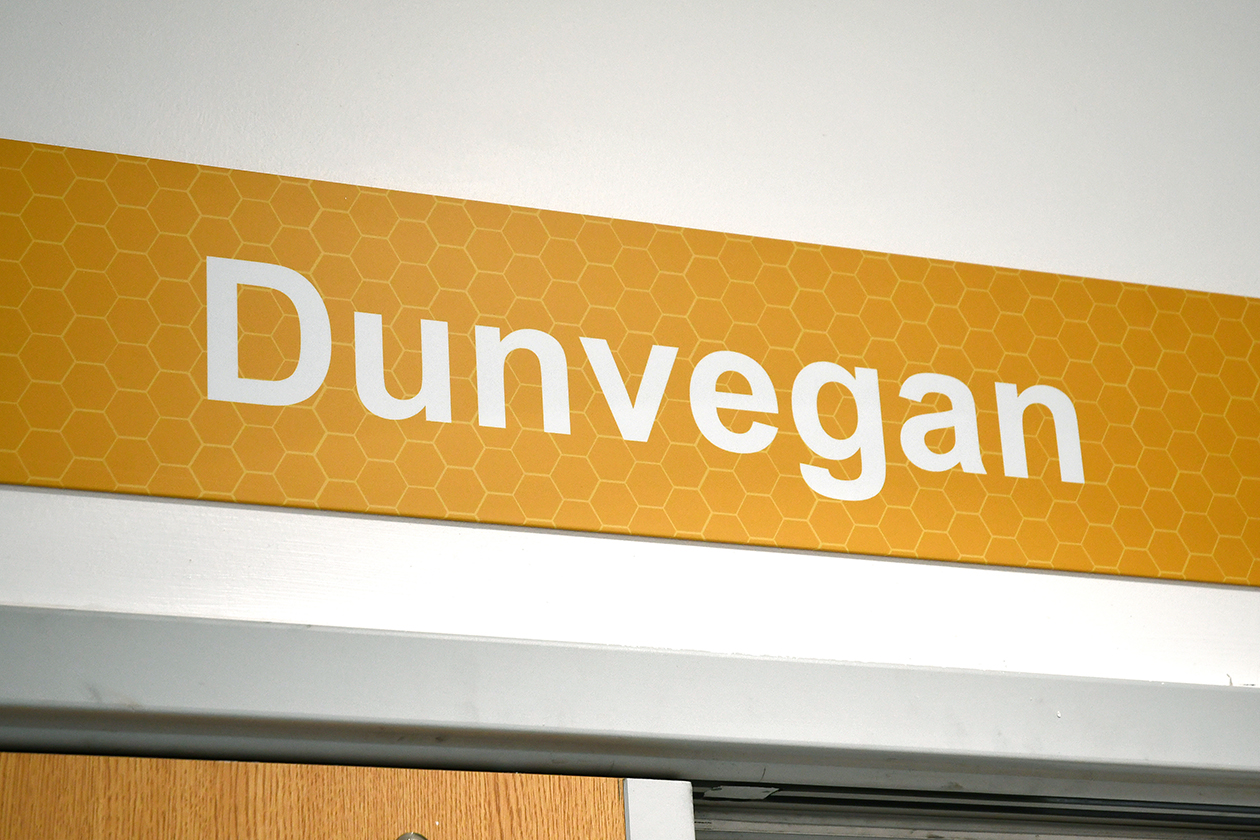 A ward sign that has white Dunvegan text on it and a yellow background with honeycomb pattern