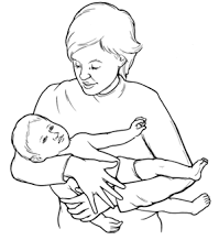 A woman holding a baby in their arms on their side with their head in the crook of their right elbow, and facing away from her. 