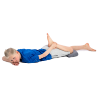 A boy is lying on his stomach and is bending his knee and pulling it towards his bottom 