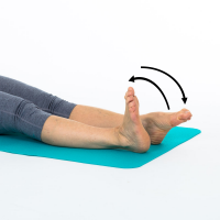 a woman is sitting with her legs in front of her. She is moving her ankles up and down and round in circles 