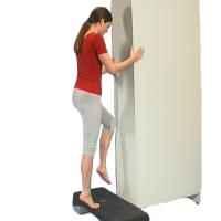 a woman is standing on a small step with her affected leg and pushing slowly up onto her toes