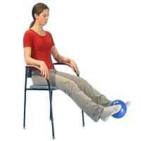 Woman sitting on a chair and lifting her feet off the floor while squeezing a ball between her ankles 
