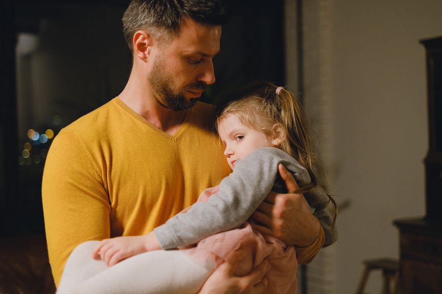 A father gently cradling his young child